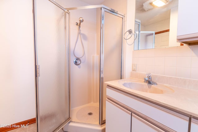 full bath with a stall shower, backsplash, and vanity