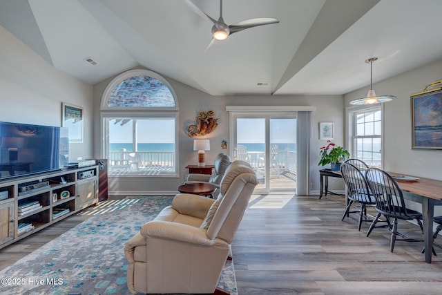 living room with a water view, visible vents, and wood finished floors