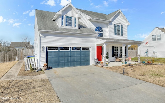 traditional-style home featuring a shingled roof, covered porch, fence, a garage, and driveway