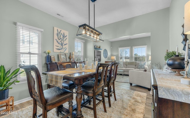 dining room with baseboards, visible vents, and light wood-style floors