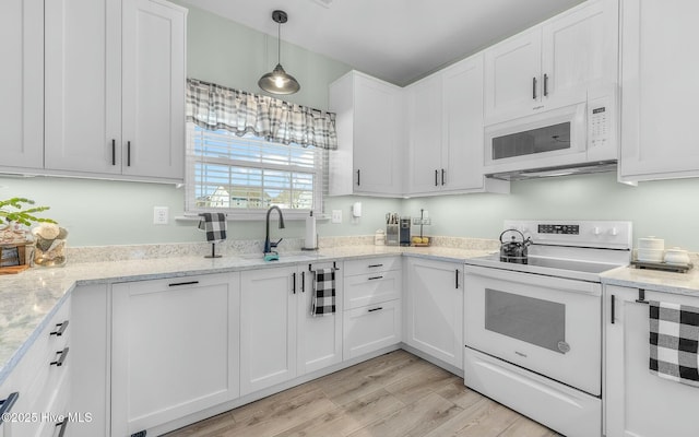 kitchen with light wood-style floors, white appliances, white cabinets, and hanging light fixtures