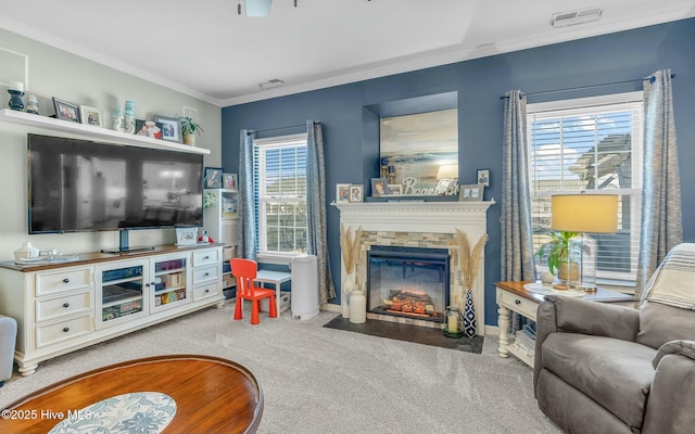 living area featuring light carpet, a fireplace with flush hearth, visible vents, and ornamental molding