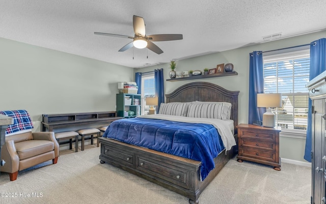 bedroom featuring light carpet, baseboards, visible vents, ceiling fan, and a textured ceiling