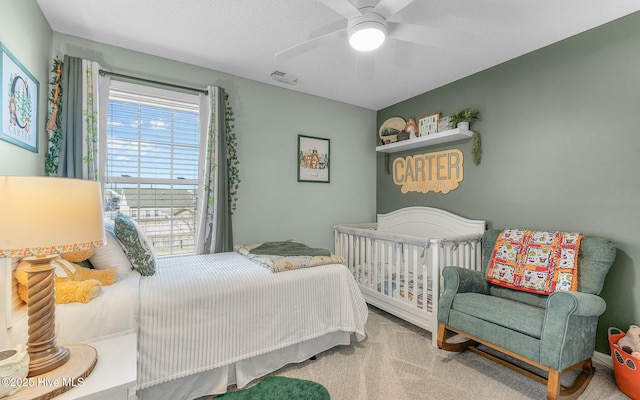 carpeted bedroom featuring a ceiling fan and visible vents