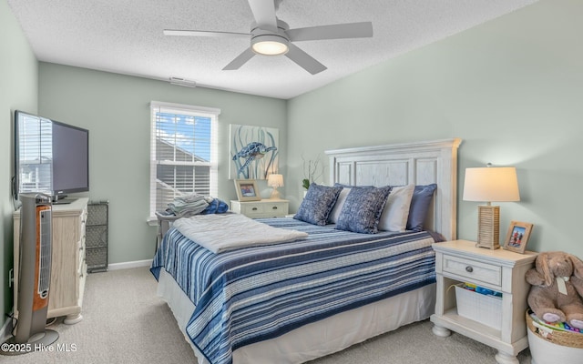 bedroom with a textured ceiling, ceiling fan, light colored carpet, visible vents, and baseboards