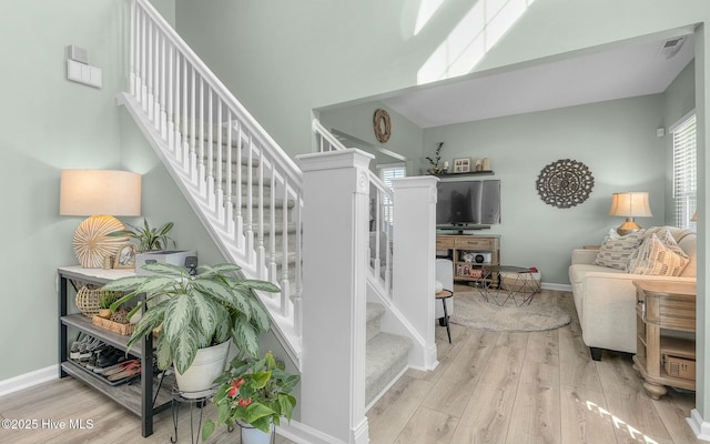 stairway with wood finished floors and baseboards