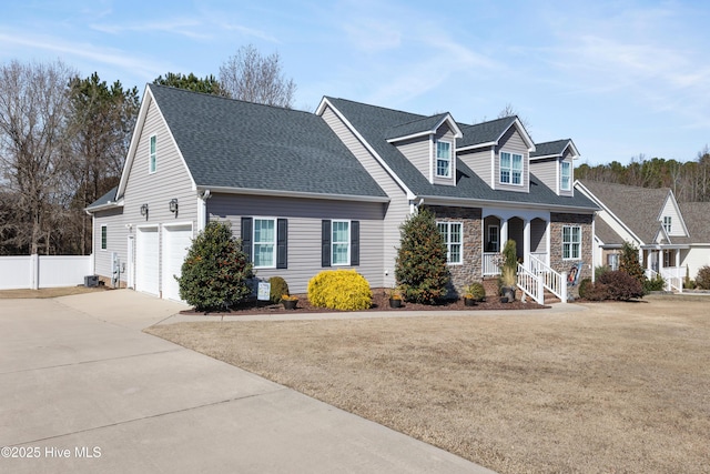 cape cod home featuring fence, a front lawn, concrete driveway, and roof with shingles