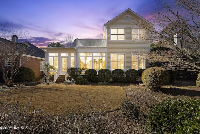 rear view of property featuring a sunroom