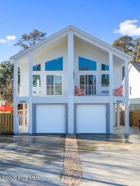 exterior space with a garage, concrete driveway, fence, and stucco siding