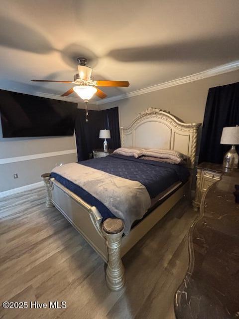 bedroom featuring ceiling fan, crown molding, and dark hardwood / wood-style floors