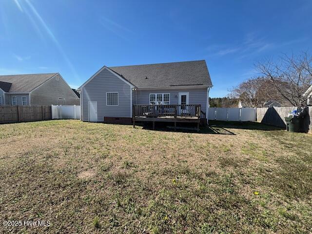 rear view of house with a lawn and a wooden deck