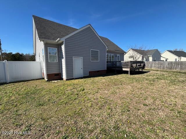 back of property with a yard and a deck