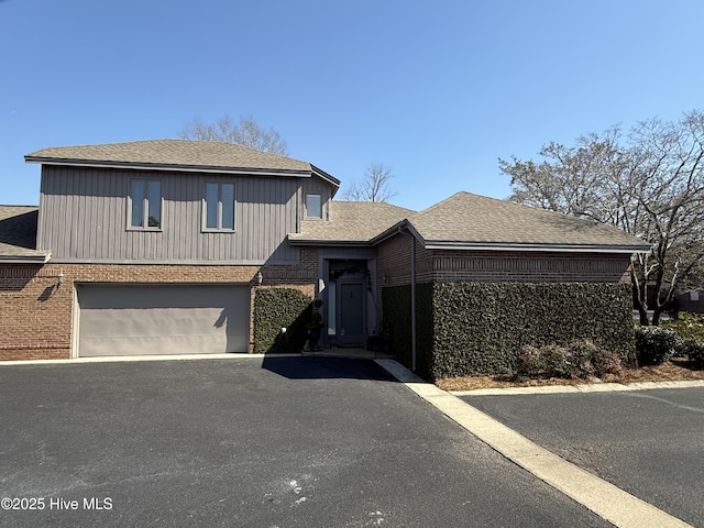 view of front of house with aphalt driveway, brick siding, a shingled roof, and a garage