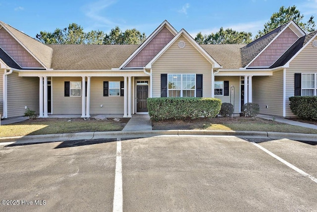 townhome / multi-family property with a shingled roof and uncovered parking