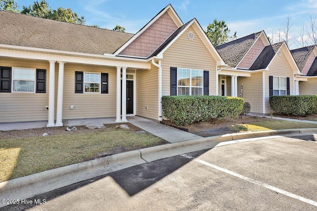 view of front facade featuring a front lawn and a shingled roof