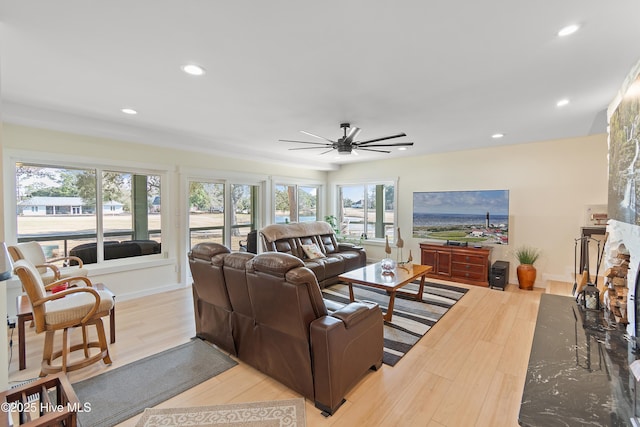 living room featuring light wood-type flooring and ceiling fan