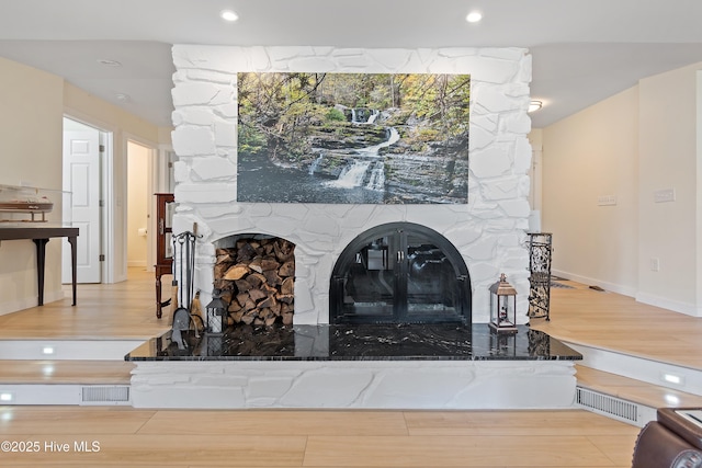 room details featuring a fireplace and wood-type flooring