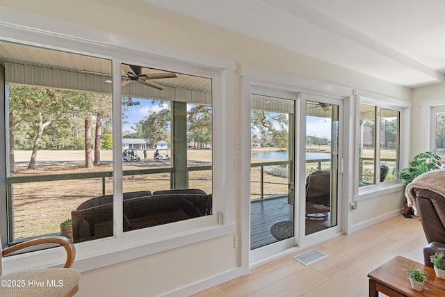 sunroom featuring a water view