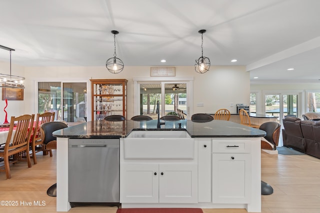 kitchen featuring white cabinetry, dark stone counters, hanging light fixtures, and dishwasher