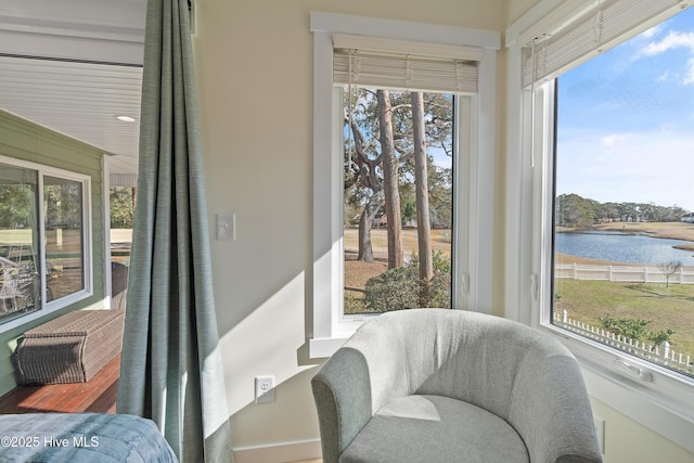 sunroom featuring a water view