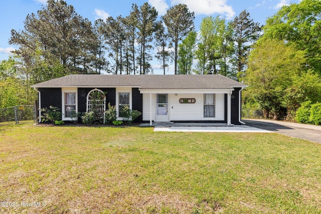 ranch-style home featuring concrete driveway, a front yard, and fence