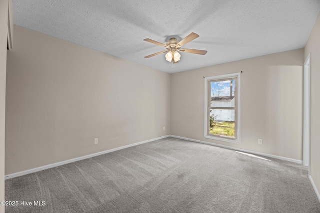 carpeted empty room with ceiling fan, baseboards, and a textured ceiling