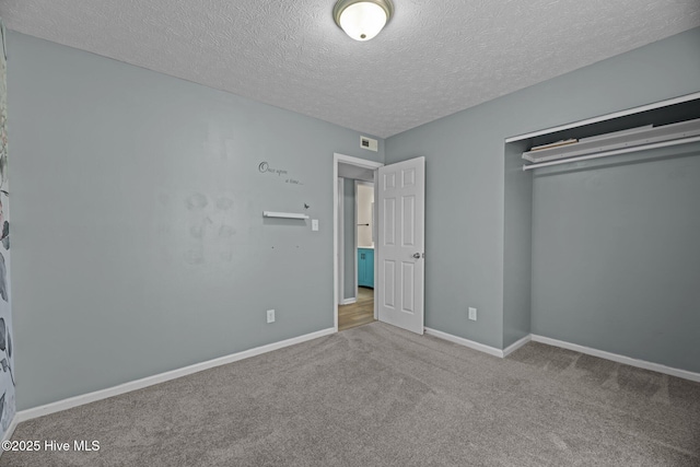 unfurnished bedroom featuring carpet floors, baseboards, a closet, and a textured ceiling