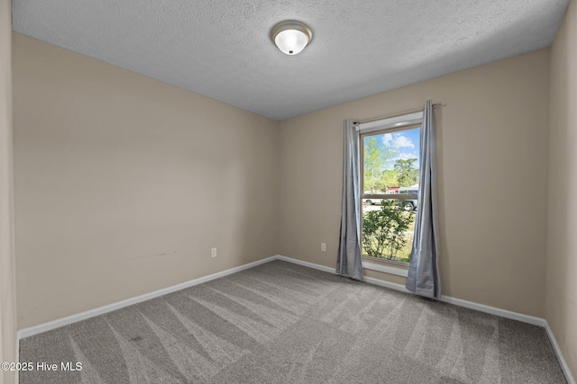 unfurnished room with baseboards, carpet flooring, and a textured ceiling
