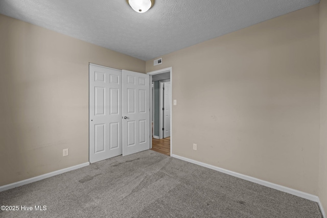 unfurnished bedroom featuring visible vents, baseboards, a closet, and carpet floors