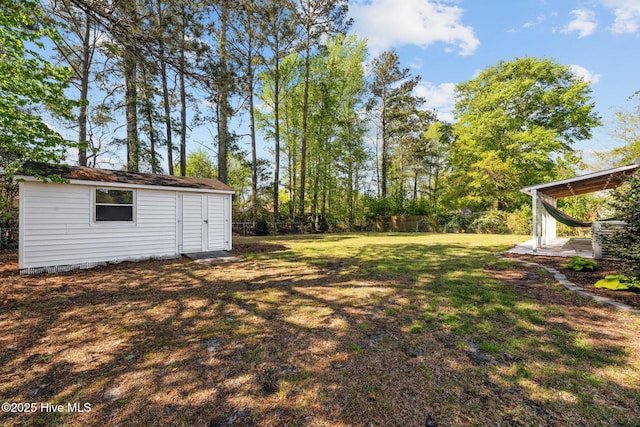 view of yard featuring a storage shed, an outbuilding, and fence