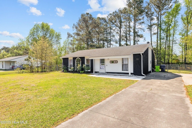 single story home featuring roof with shingles, driveway, a front yard, and fence