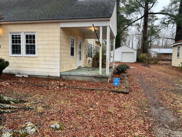 view of home's exterior with a garage and an outbuilding