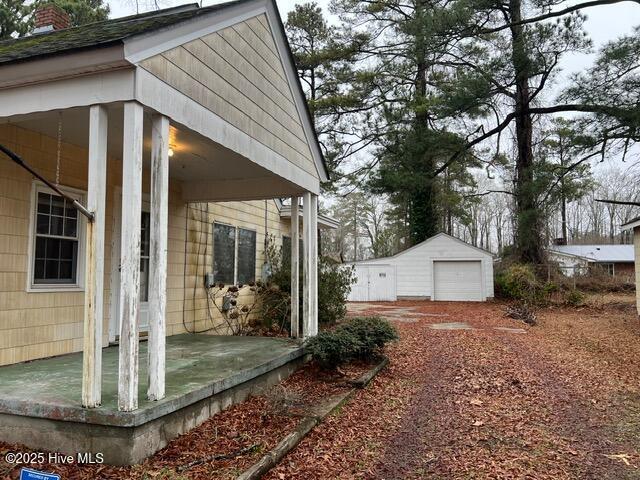 view of home's exterior with a garage and an outbuilding