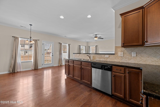 kitchen featuring tasteful backsplash, dark wood-type flooring, a sink, plenty of natural light, and dishwasher