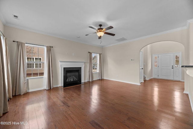 unfurnished living room featuring arched walkways, wood-type flooring, a fireplace with flush hearth, and visible vents