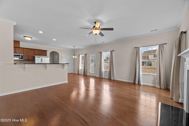 unfurnished living room with plenty of natural light, a ceiling fan, and hardwood / wood-style floors