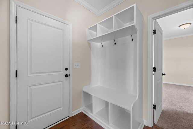 mudroom with baseboards, dark carpet, and crown molding