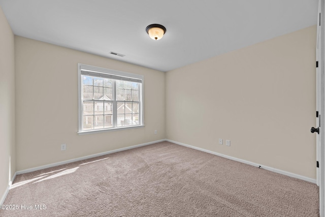 carpeted empty room with visible vents and baseboards