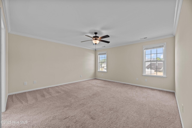 carpeted spare room featuring baseboards, a ceiling fan, visible vents, and crown molding