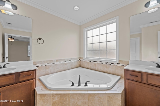 full bathroom featuring a garden tub, two vanities, a sink, visible vents, and ornamental molding