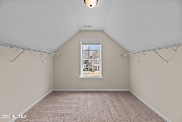 walk in closet with carpet, visible vents, and vaulted ceiling