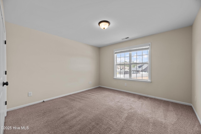 unfurnished room with carpet floors, baseboards, and visible vents