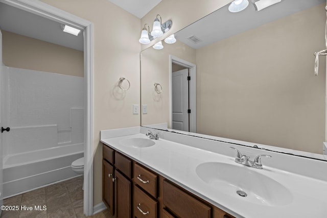 full bath with toilet, double vanity, a sink, and visible vents