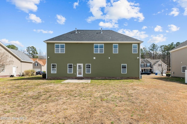 rear view of house featuring a lawn and a patio