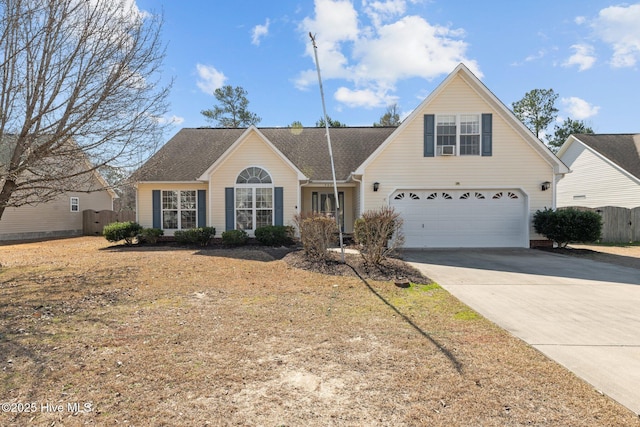 traditional-style home with a garage, driveway, and fence