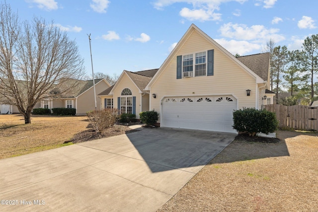 traditional-style home featuring a garage, a gate, driveway, and fence