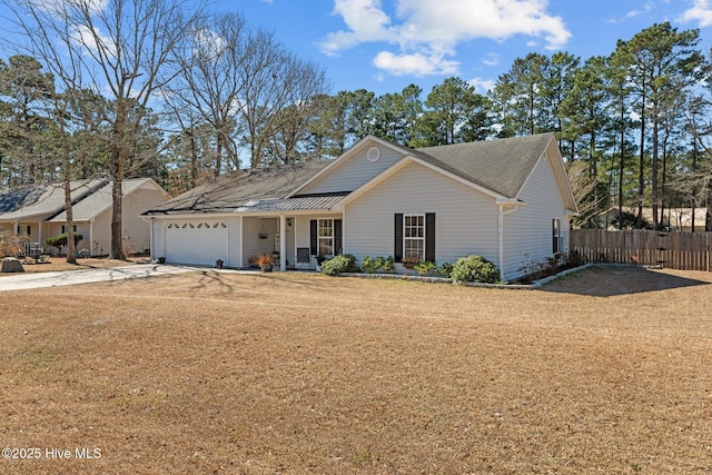 ranch-style home featuring an attached garage, fence, a front lawn, and concrete driveway