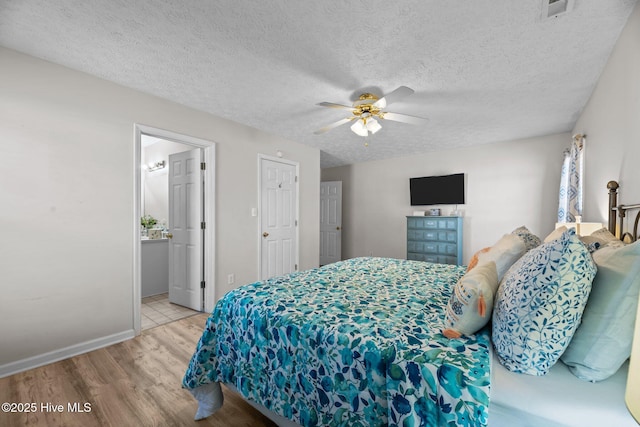 bedroom with a textured ceiling, wood finished floors, a ceiling fan, and baseboards