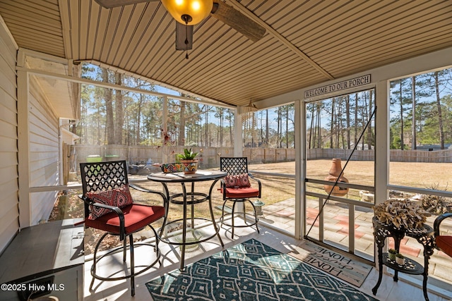 sunroom with lofted ceiling and a ceiling fan