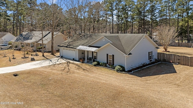 view of front facade featuring driveway, an attached garage, and fence